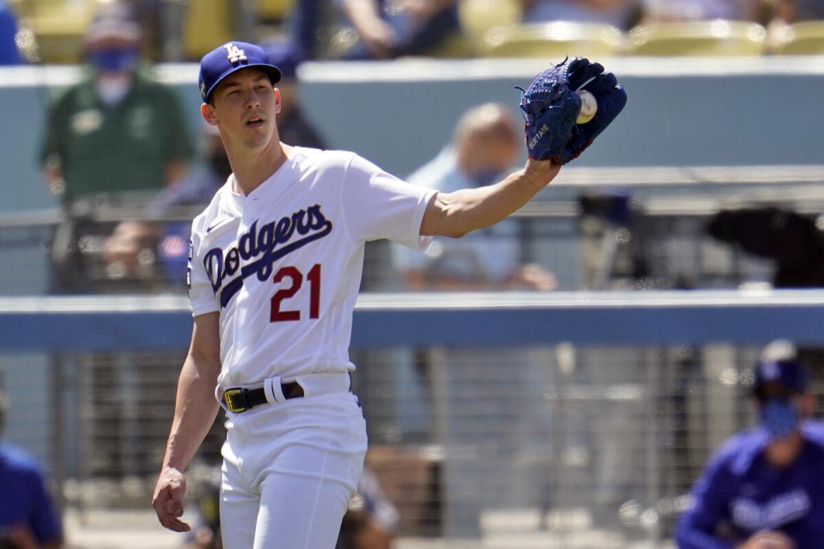 Los Angeles Dodgers starting pitcher Walker Buehler gets the ball back from the infield after recording.