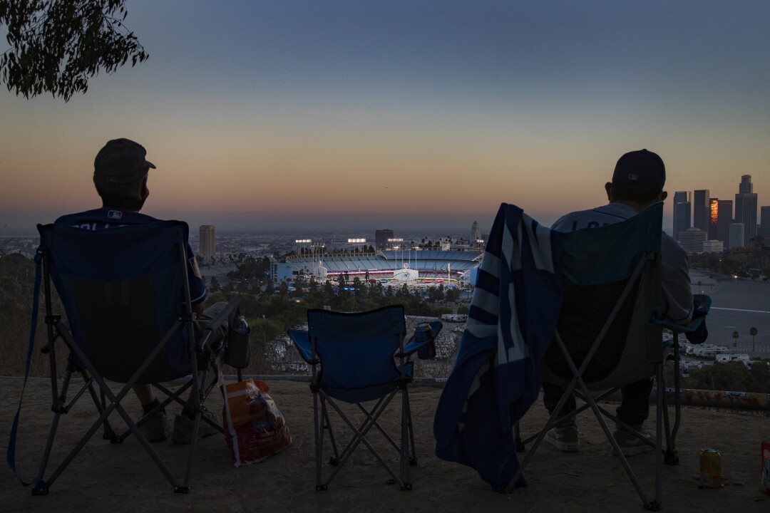 Season ticket holder Keith Hupp, left, and David Lopez, right, watch the Dodgers play