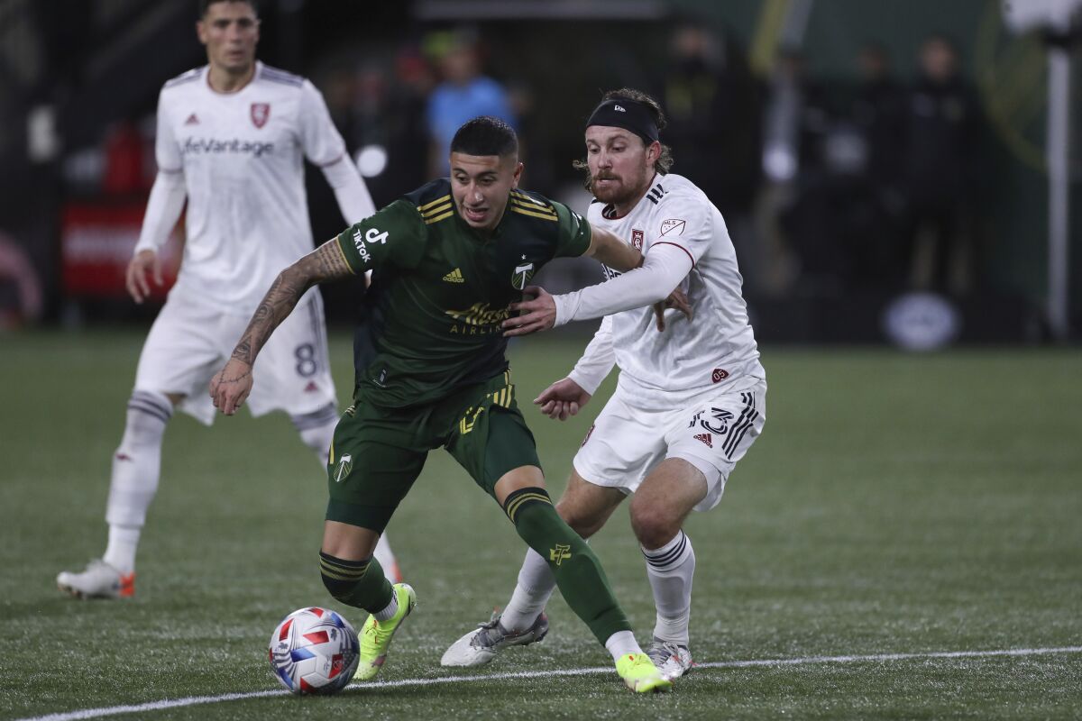 Portland Timbers midfielder Marvin Loria, front left, and Real Salt Lake midfielder Nick Beslern (13) compete for the ball during the first half of the MLS soccer Western Conference final Saturday, Dec. 4, 2021, in Portland, Ore. (AP Photo/Amanda Loman)