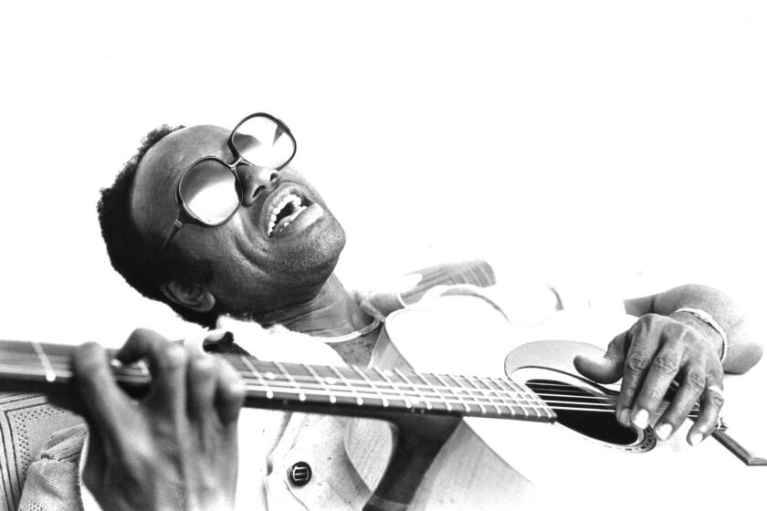 Guitarist and singer Bobby Womack plays acoustic guitar as he poses for a portrait circa 1982 in London. Womack died on Friday at 70.