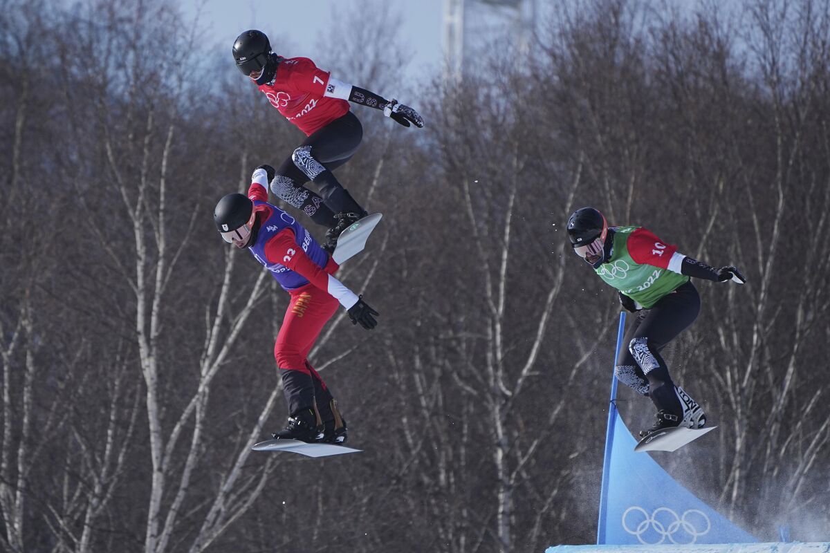 Japan's Yoshiki Takahara (23), United States' Hagen Kearney (7) and United States' Nick Baumgartner (10) run the course during the men's cross finals at the 2022 Winter Olympics, Thursday, Feb. 10, 2022, in Zhangjiakou, China. (AP Photo/Gregory Bull)