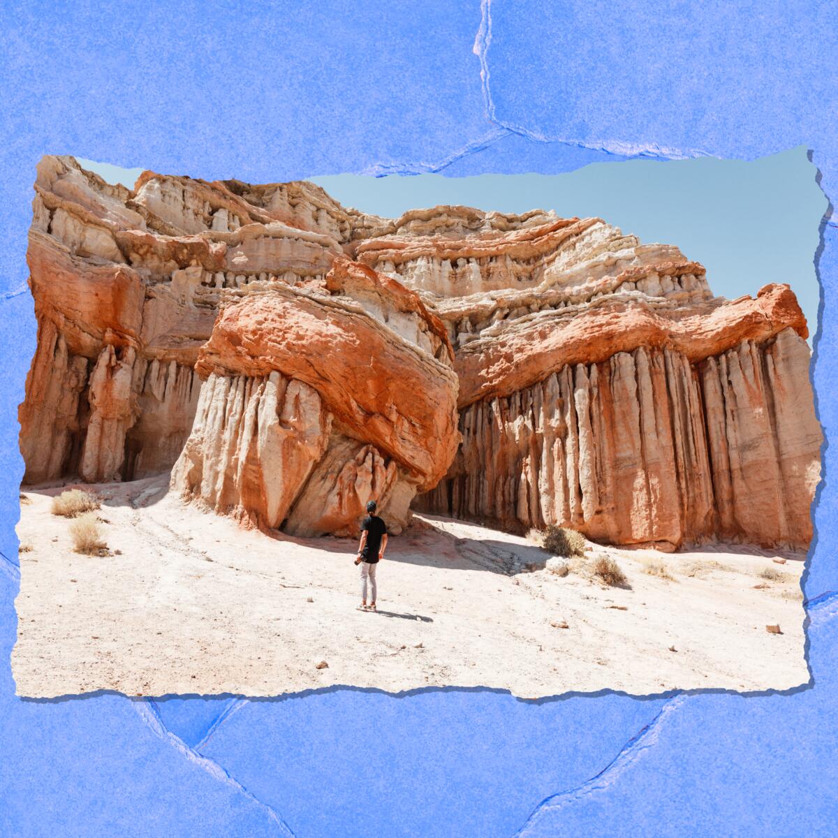 A person is dwarfed by intricately eroded boulders.