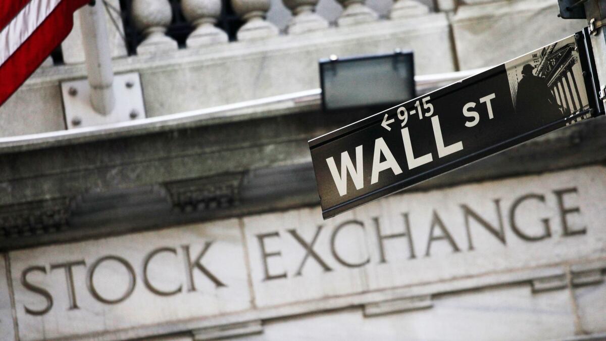 A Wall Street street sign stands outside the New York Stock Exchange.