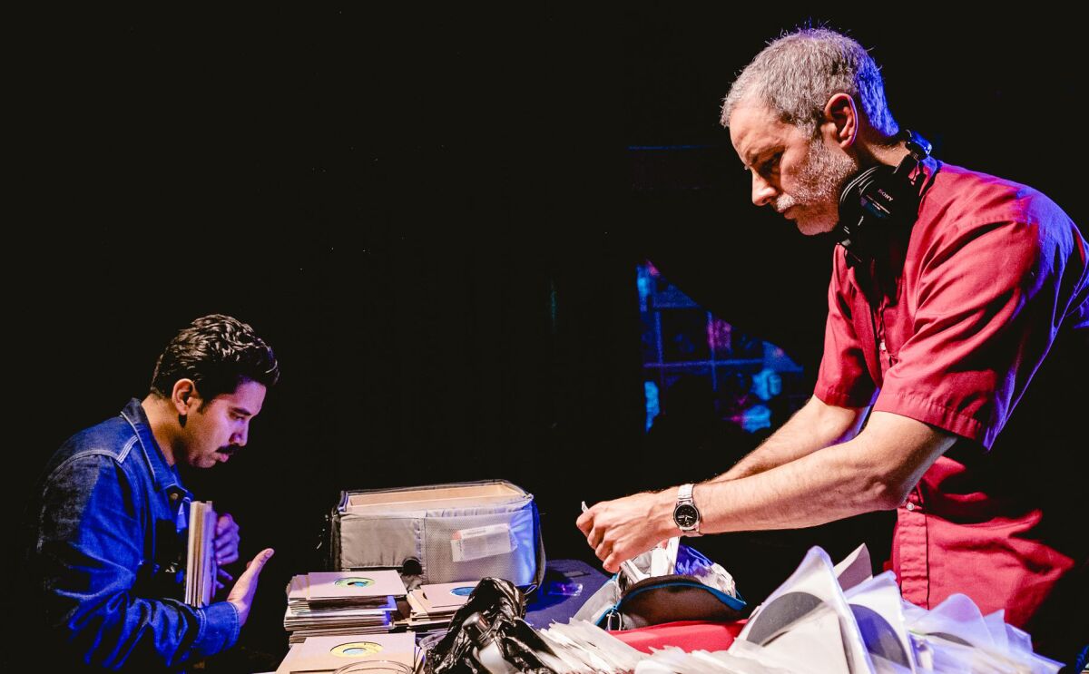 Two men look through records.