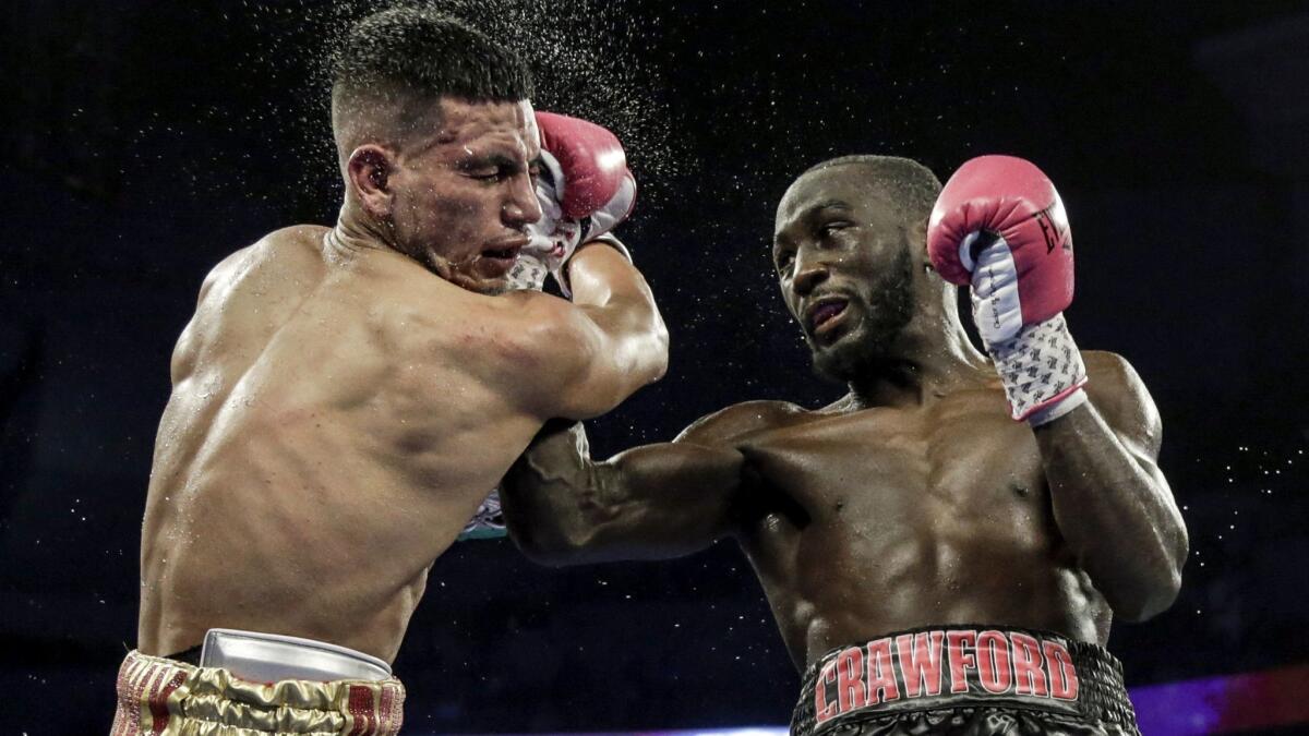 Terence Crawford, right, delivers an uppercut right that knocked down Jose Benavidez during a fight in October.