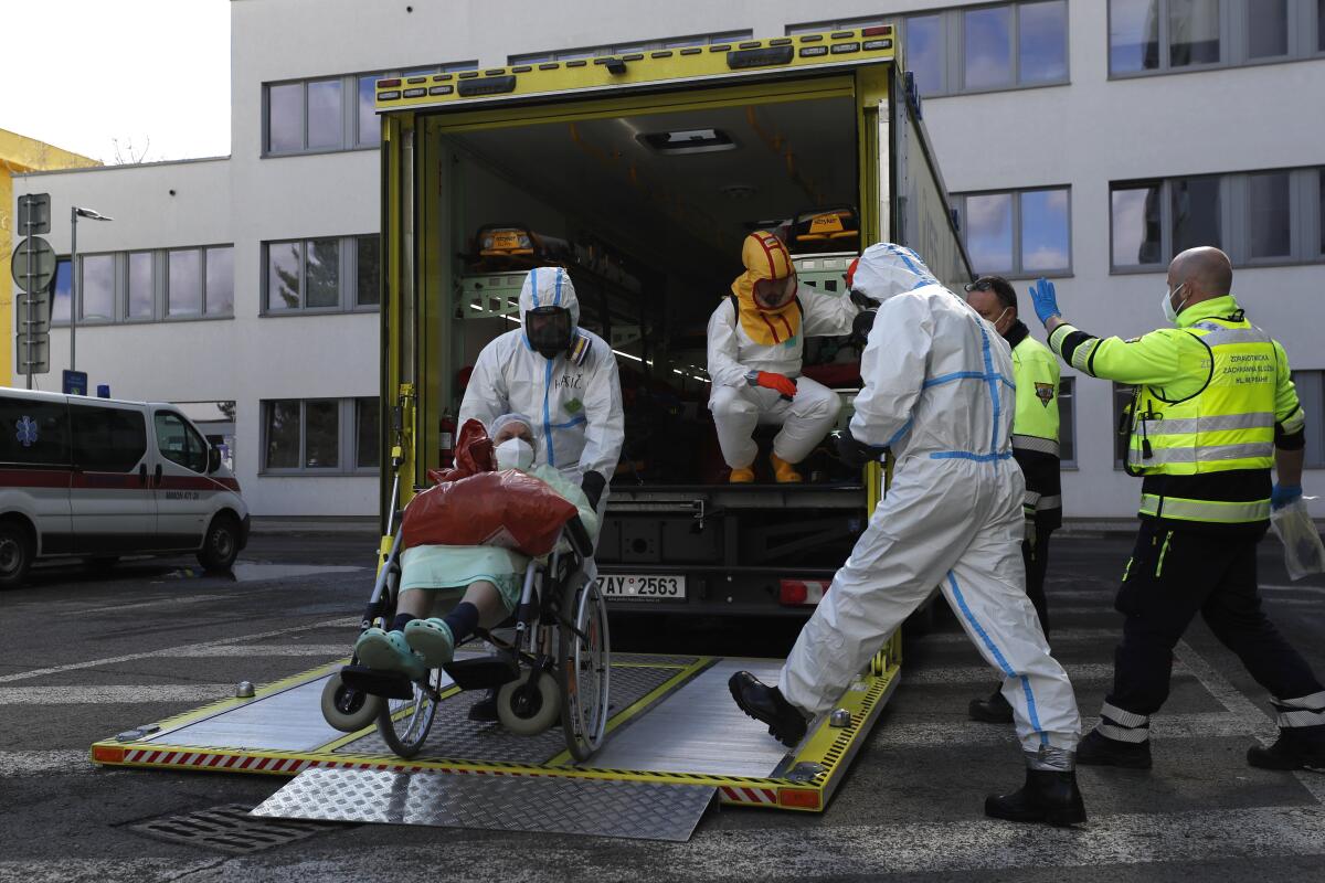 FILE - Health care workers transport a COVID-19 patient, in Ceska Lipa, Czech Republic, Thursday, March 18, 2021. Coronavirus infections in the Czech Republic have soared to a record level again, reaching almost 26,000 daily cases. The Health Ministry says the daily tally hit 25,864 on Tuesday, Nov. 23, 2021, about 3,000 more than the previous record registered on Friday.(AP Photo/Petr David Josek, File)