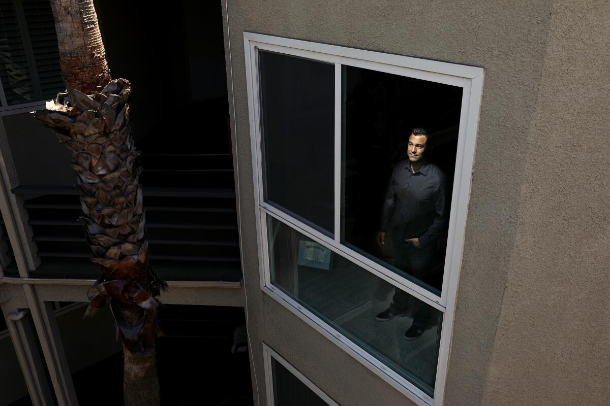 Jason Reid stands in his condominium in Los Angeles.