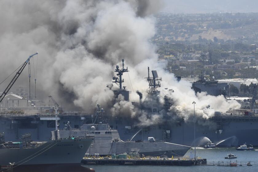 Smoke rises from the USS Bonhomme Richard at Naval Base San Diego Sunday, July 12, 2020, in San Diego after an explosion and fire Sunday on board the ship at Naval Base San Diego. (AP Photo/Denis Poroy)