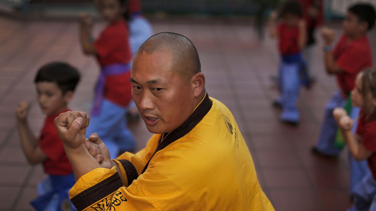 Master Shi Yanxu teaches the martial art of kung fu to children at the Far East Plaza in Chinatown.
