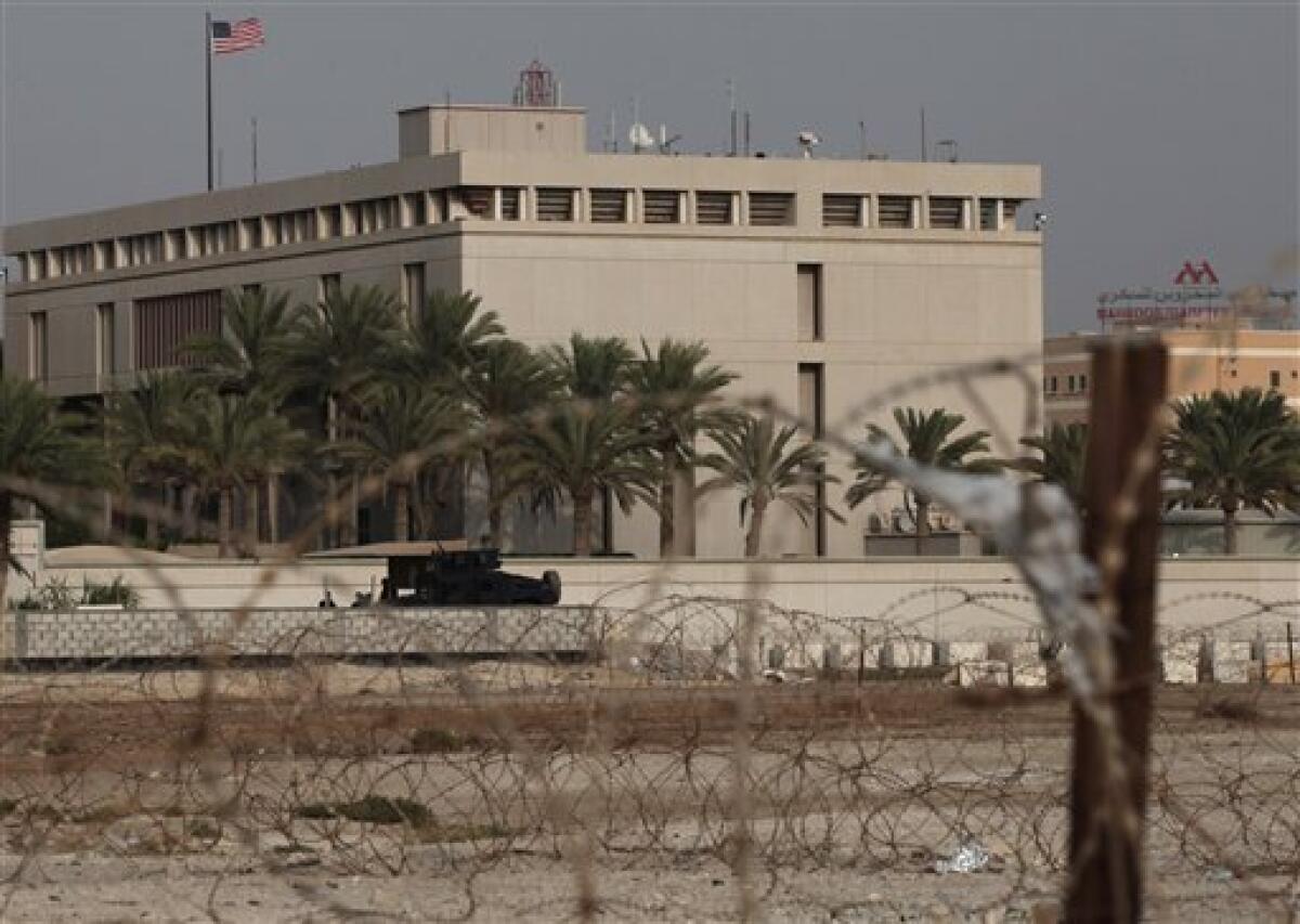 A Bahraini armored personnel vehicle and personnel reinforce U.S. Embassy security just outside a gate to the building, surrounded in barbed wire, in Manama, Bahrain.