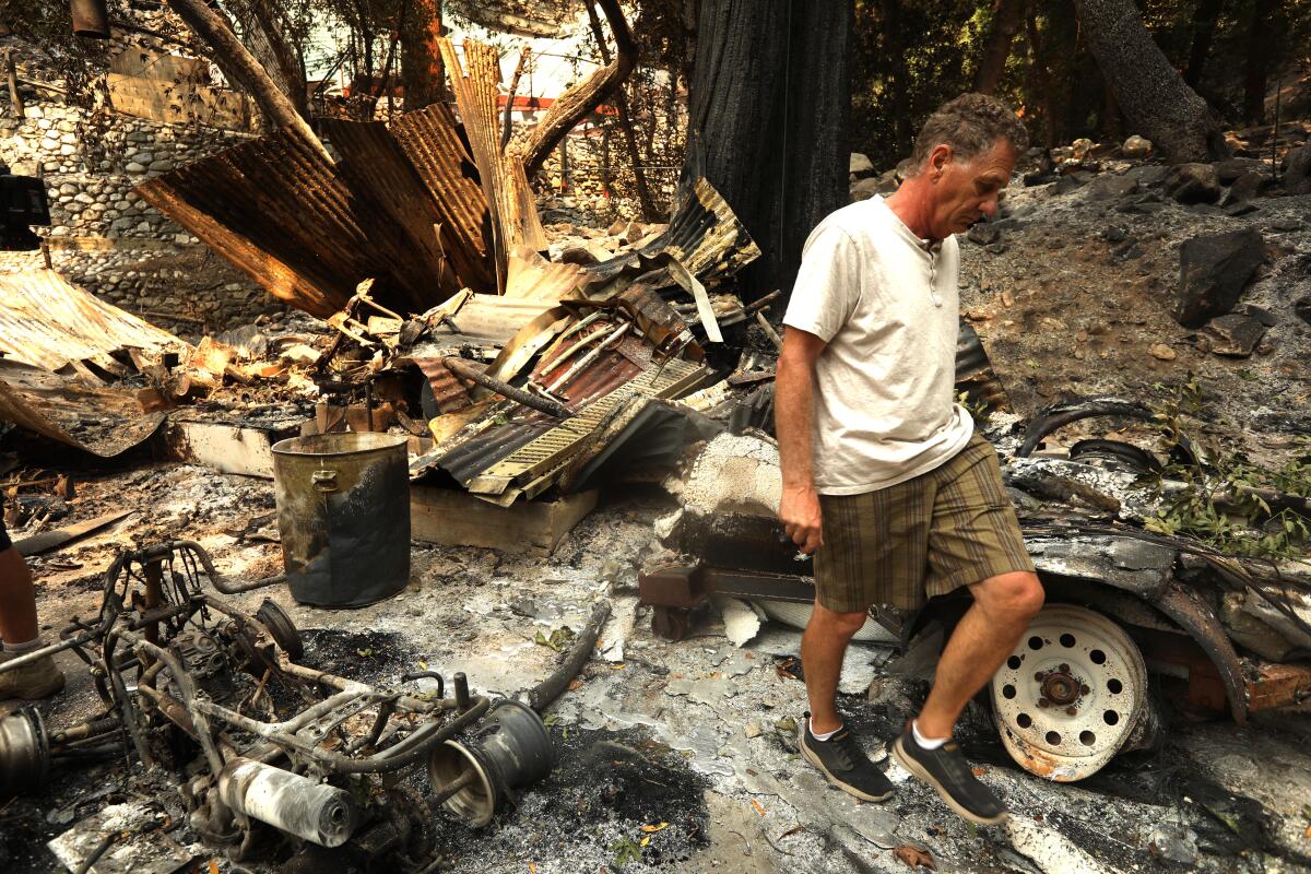 Paul Faulstick walks among the ruins of his friend's property that was destroyed in the Bridge fire.