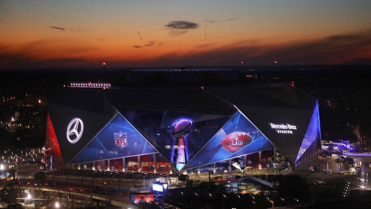 The sun sets behind Mercedes-Benz Stadium in Atlanta on Wednesday ahead of Sunday's Super Bowl LIII between the Rams and New England Patriots.