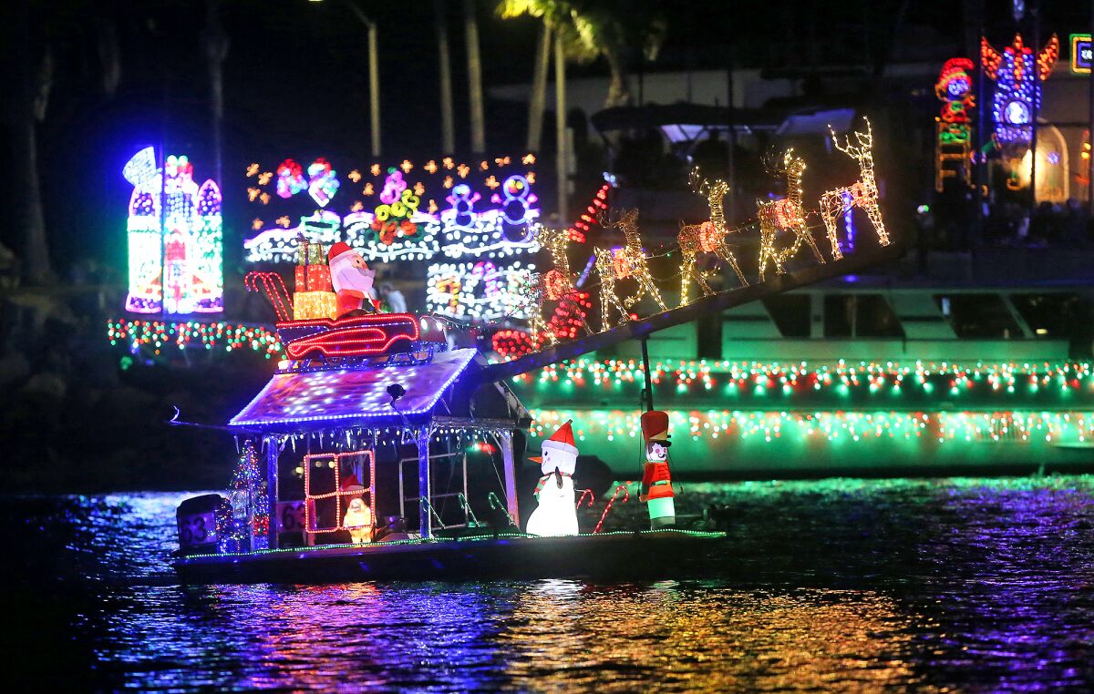 A small boat with a big Santa moves along the route of the Newport Beach Christmas Boat Parade.