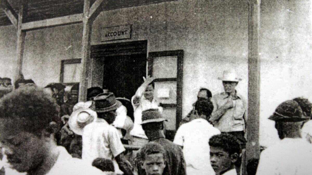 A photo from April 1971 shows John Todd, center, administrator of the island of Diego Garcia, telling residents that they will be deported because the island had been sold.