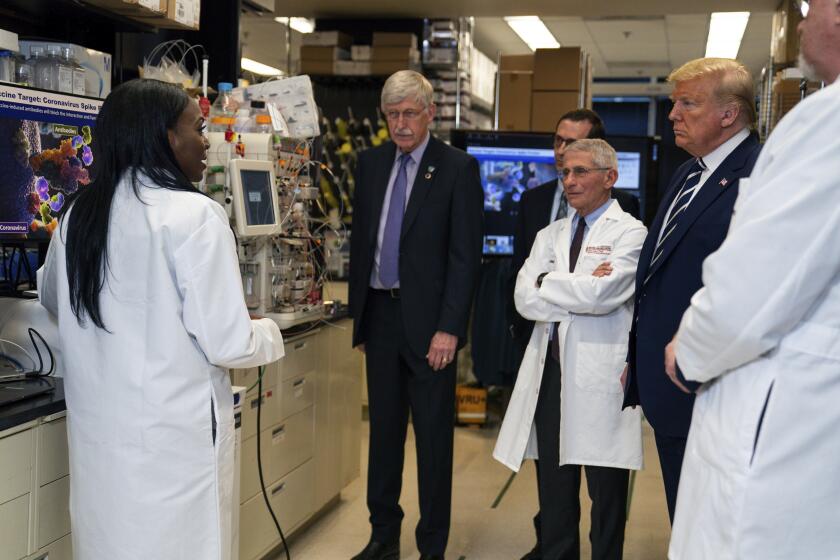 Investigadores hablan con el presidente Donald Trump sobre el desarrollo de una vacuna para el coronavirus, en los Institutos Nacionales de Salud, en Maryland, el 3 de marzo de 2020. (AP Foto/Evan Vucci)