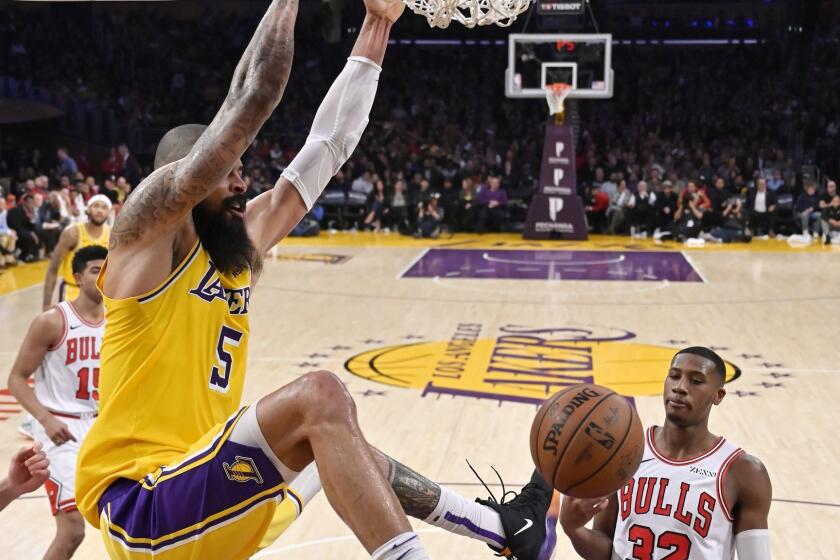 Los Angeles Lakers center Tyson Chandler, left, dunks as Chicago Bulls guard Kris Dunn watches during the second half of an NBA basketball game Tuesday, Jan. 15, 2019, in Los Angeles. The Lakers won 107-100. (AP Photo/Mark J. Terrill)