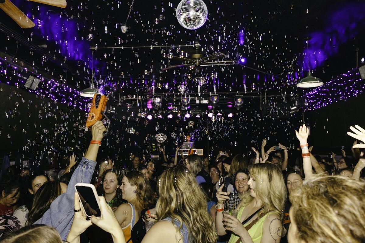 Attendees dance under a disco ball and a sea of bubbles at a recent Earlybirds Club party.