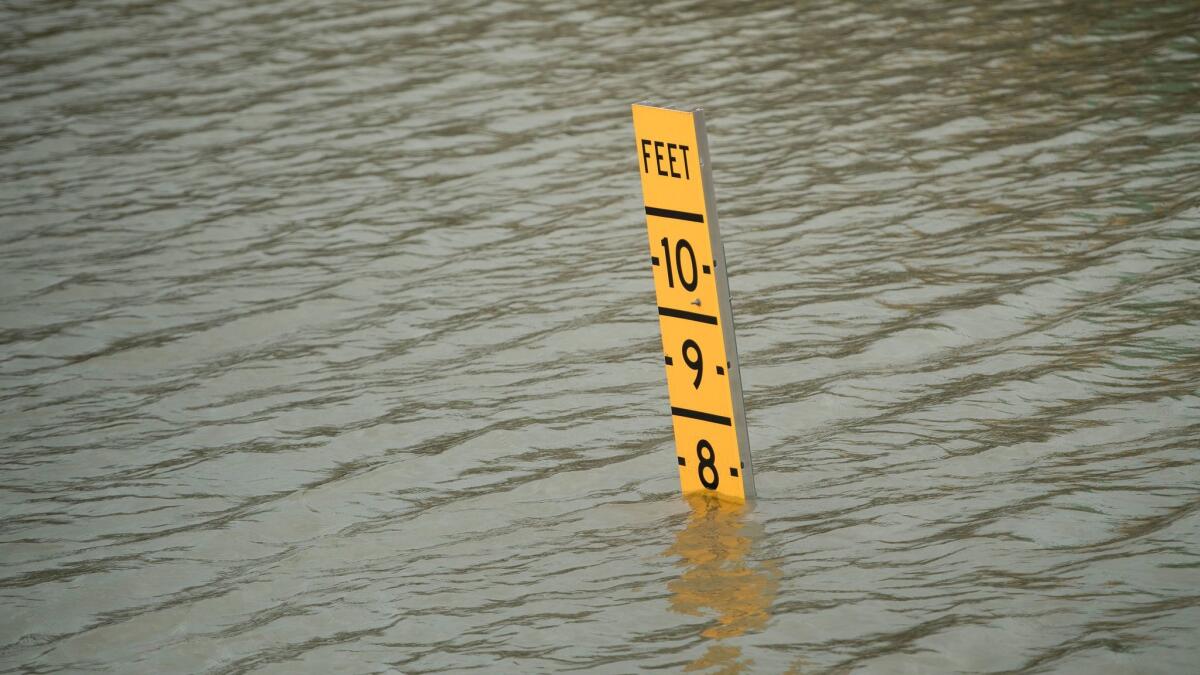 A sign indicates the height of floodwaters on Route 288 in Houston, Texas, in the aftermath of Hurricane Harvey on Sunday. The storm has shut ports in Galveston and Houston, and left cruise ships waiting out the storm in the Gulf of Mexico.