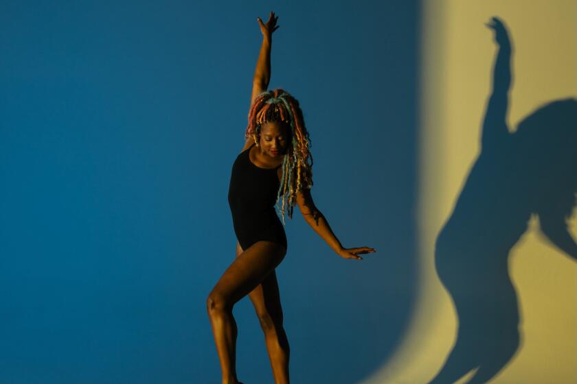Ballet dancer Whitney Edwards poses in front of a blue background.