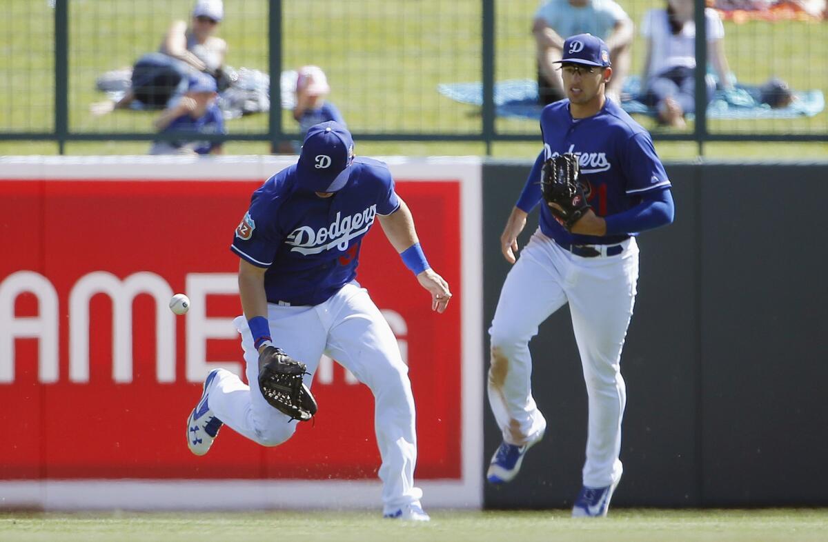 Dodgers outfielder Joc Pederson, left, drops a fly ball hit by Indians' Juan Uribe as Dodgers' Trayce Thompson, right, looks on during the fifth inning.