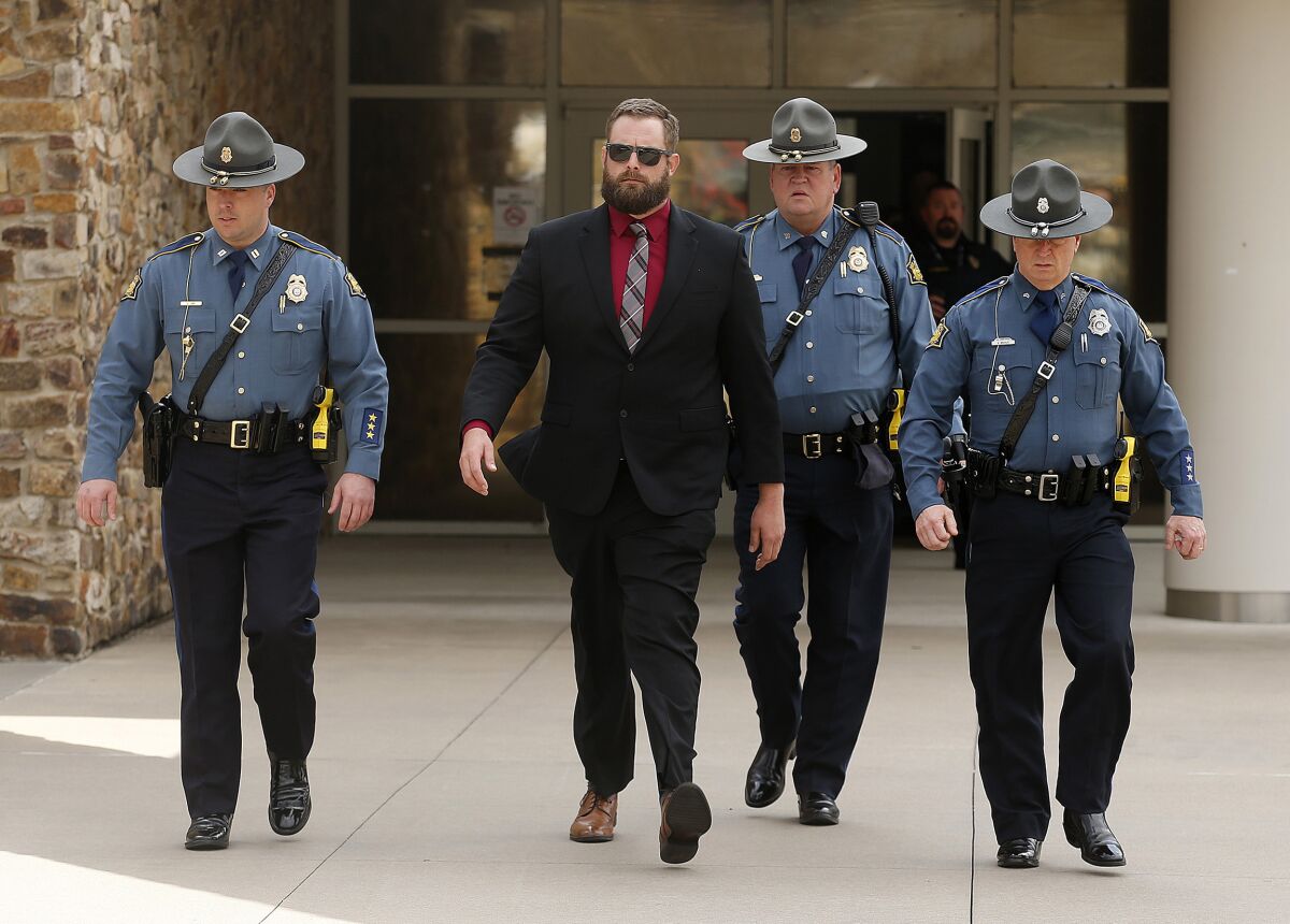 Arkansas State Troopers escort former Lonoke County sheriff's deputy Michael Davis, left center, after being convicted of negligent homicide on Friday, March 18, 2022, at the Cabot Readiness Center in Cabot, Ark. Jurors acquitted Michael Davis of the more serious offense of manslaughter while finding him guilty of the misdemeanor charge in the death of 17-year-old Hunter Brittain during a June 23 traffic stop outside Cabot. (Thomas Metthe/The Arkansas Democrat-Gazette via AP)