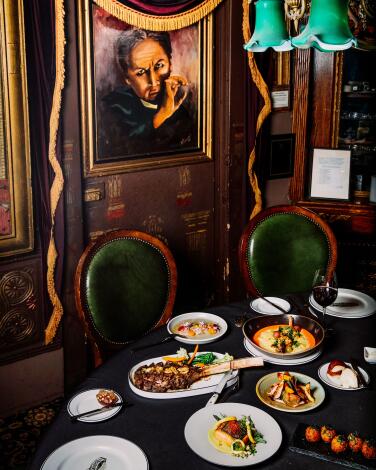 A portrait of Houdini above a table in a restaurant. 