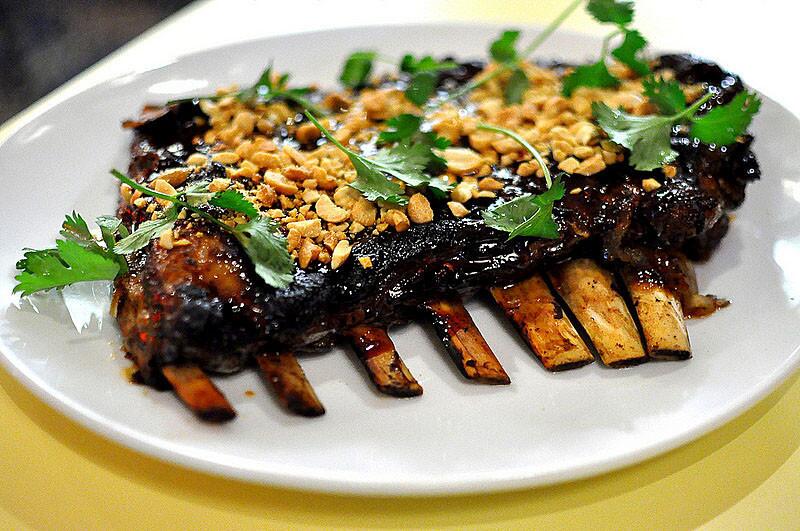 Lamb ribs are slicked with a tamarind glaze and topped with cilantro and peanuts.