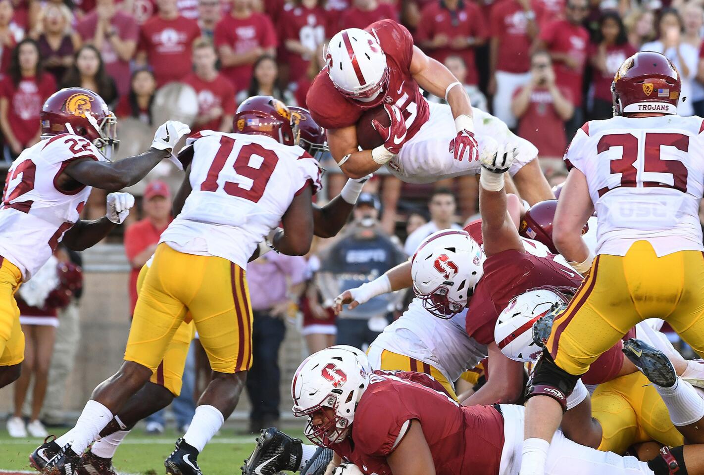 Stanford running back Christian McCaffrey dives over the USC defenders but is stopped short of the goal line. McCaffrey would score a touchdown on the next play.