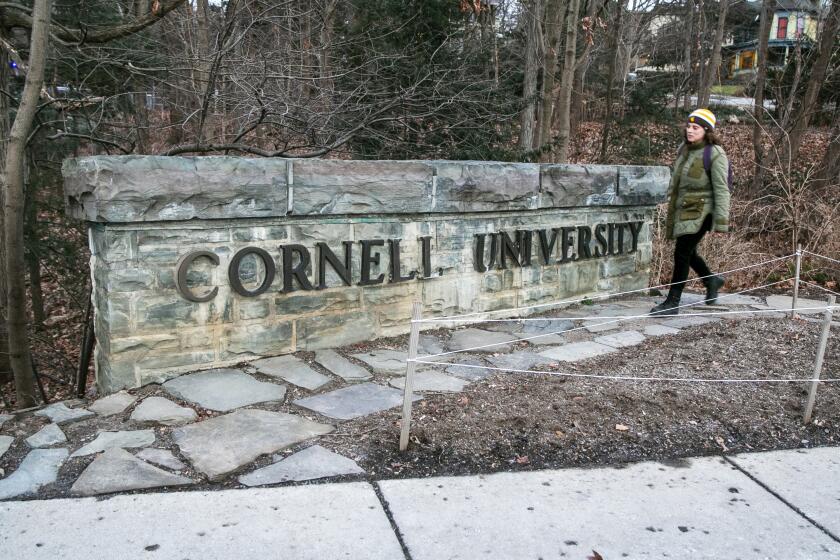 FILE - A woman walks by a Cornell University sign on the Ivy League school's campus in Ithaca, New York, on Jan. 14, 2022. The Cornell University student accused of making online threats against Jewish people on campus had mental health struggles and apparently showed remorse soon after, according to his mother, Monday, Nov. 6, 2023.(AP Photo/Ted Shaffrey, File)