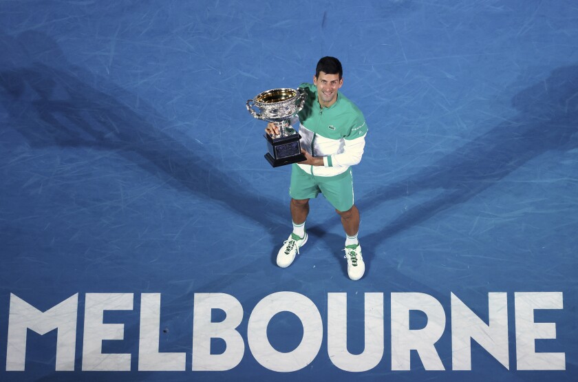 FILE - Serbia's Novak Djokovic holds the Norman Brookes Challenge Cup after defeating Russia's Daniil Medvedev in the men's singles final at the Australian Open tennis championship in Melbourne, Australia, Sunday, Feb. 21, 2021. Djokovic has had his visa canceled and been denied entry to Australia, Thursday, Jan. 6, 2022, and is set to be removed from the country after spending the night at the Melbourne airport as officials refused to let him enter the country for the Australian Open after an apparent visa mix-up.(AP Photo/Hamish Blair, File)