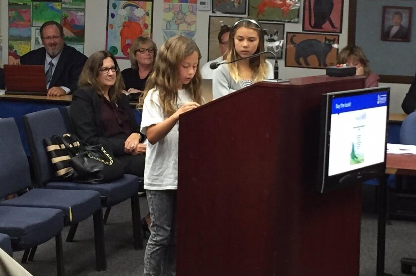 Students Kaiya Luevano, left, and Lillian Brown speak at an Oceanside Unified School District board meeting.