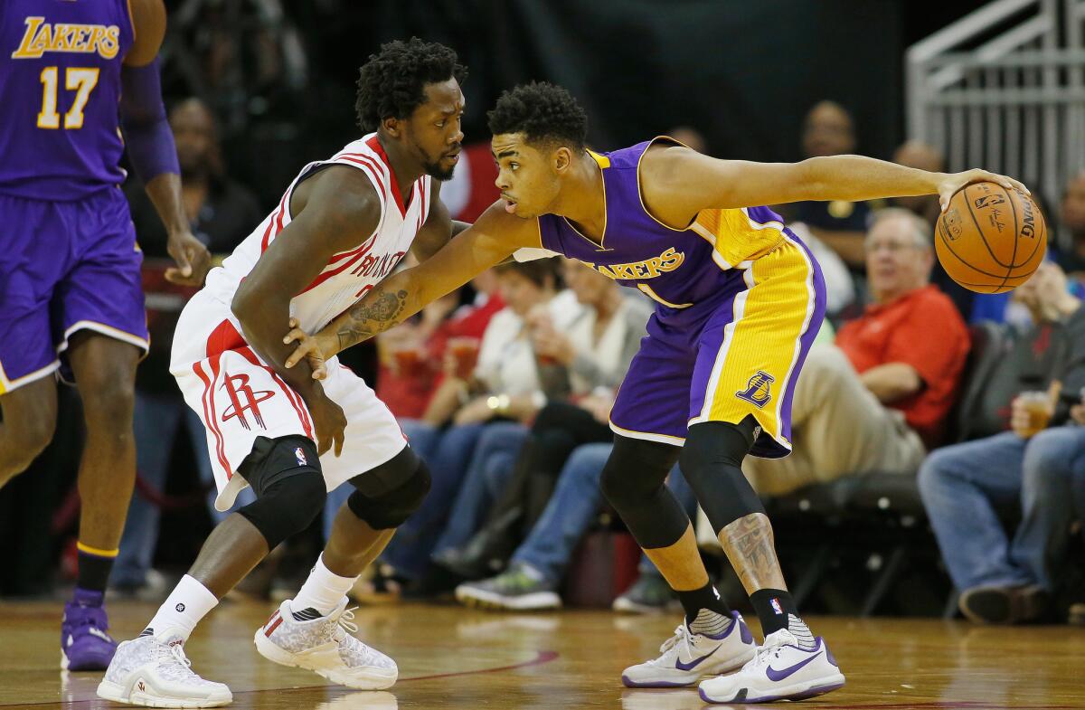 Lakers rookie point guard D'Angelo Russell keeps the ball away from Rockets guard Patrick Beverley on the wing.