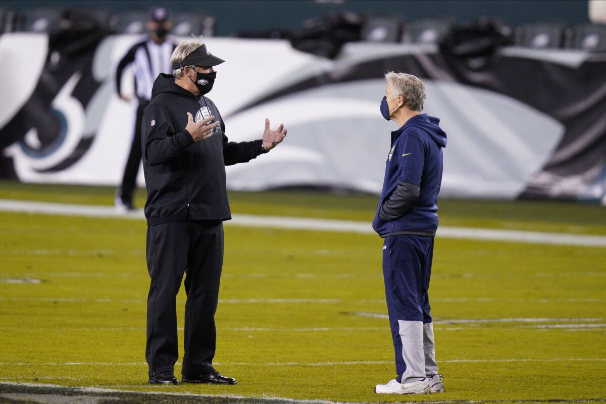 Philadelphia Eagles head coach Doug Pederson, left, and Seattle Seahawks head coach Pete Carroll talk before a game Monday.
