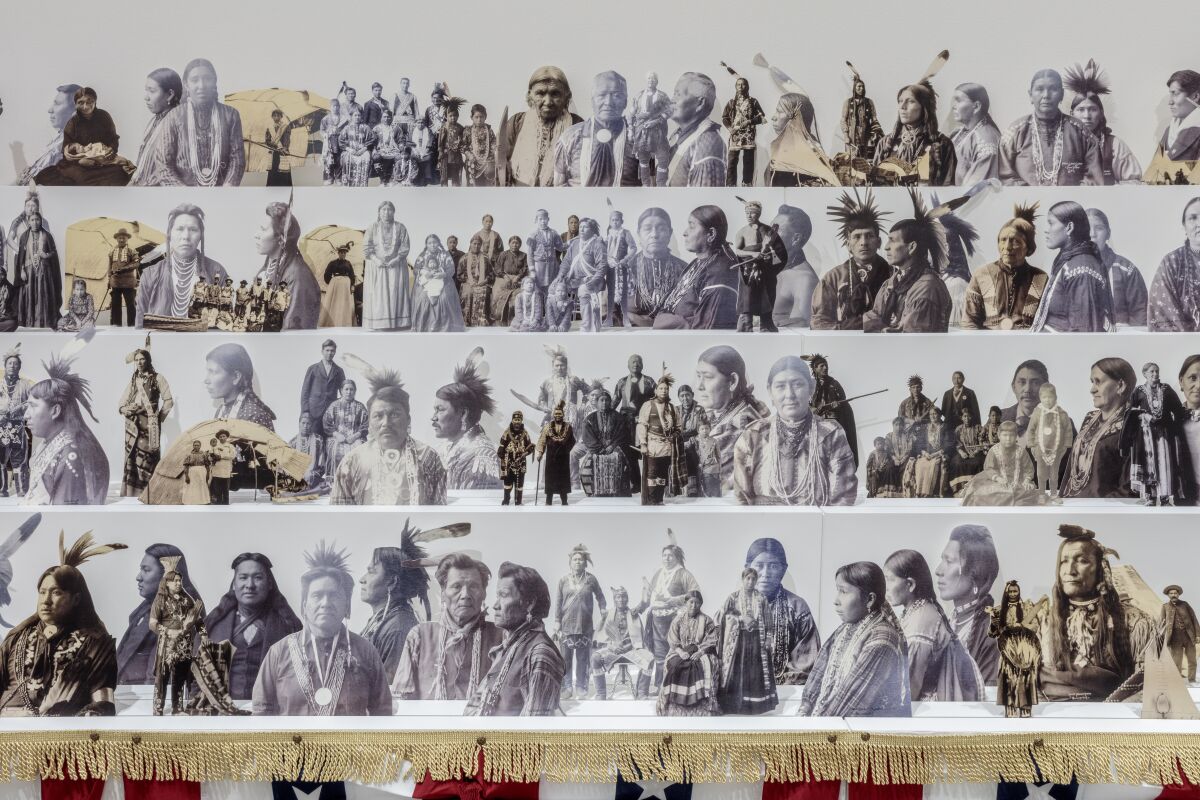 A detail of an installation by Wendy Red Star shows cutouts of vintage images of Indigenous leaders propped on risers