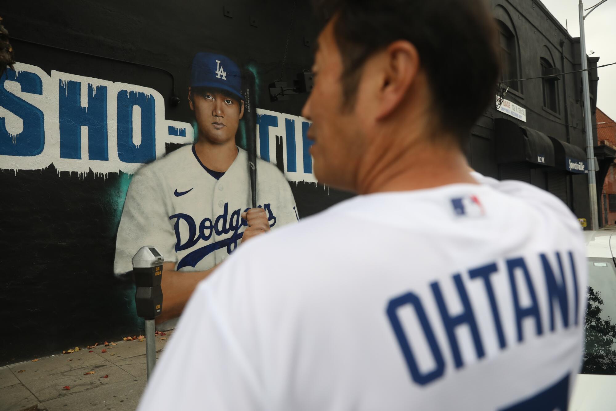 Fan Kazuo Imai is wearing a Shohei Ohtani Dodgers jersey when he views Ohtani mural in downtown Los Angeles.