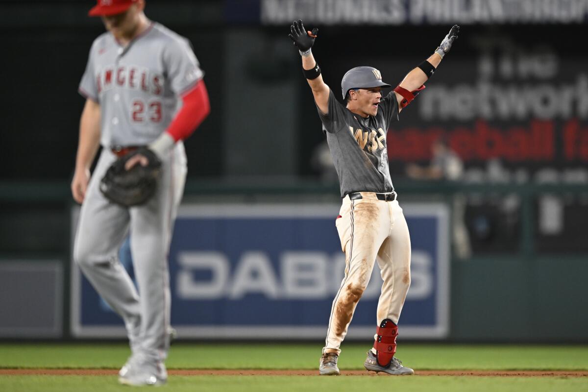 Washington's Alex Call, right, celebrates as Angels first baseman Brandon Drury walks off the field.