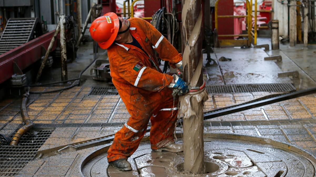 In this 2013 photo, Vicente Gonzalez works a deep-water oil drilling platform off the coast of Veracruz, Mexico.