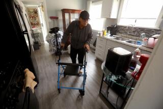 EL SERENO, CA - APRIL 5, 2024 - - Maria Merritt, 56, makes her way through the kitchen in the home she reclaimed on Sheffield Avenue in El Sereno on April 5, 2024. She starts using her walker midday due to residual pain from knee surgery. In March 2020, after seven decades of activism against a planned-then-abandoned freeway and at the start of a global health pandemic, Merritt and 11 other homeless and housing insecure individuals and families decided to seize empty, Caltrans-owned homes. They called themselves Reclaimers. For a two-year stretch, Merritt and the others lived in the homes legally after signing leases with the city housing authority. But those agreements have long since expired. Eviction lawsuits are proceeding in Los Angeles Superior Court, with trials scheduled for this spring. No matter the outcome, Merritt says she's not leaving again. (Genaro Molina/Los Angeles Times)