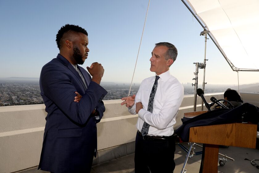 LOS ANGELES, CA - APRIL 19: Los Angeles Mayor Eric Garcetti, right, talks with Michael Tubbs, left, founder of Mayors for a Guaranteed Income, after holding his annual State of the City address from the Griffith Observatory Monday, April 19, 2021 in Los Angeles, CA. (Gary Coronado / Los Angeles Times)