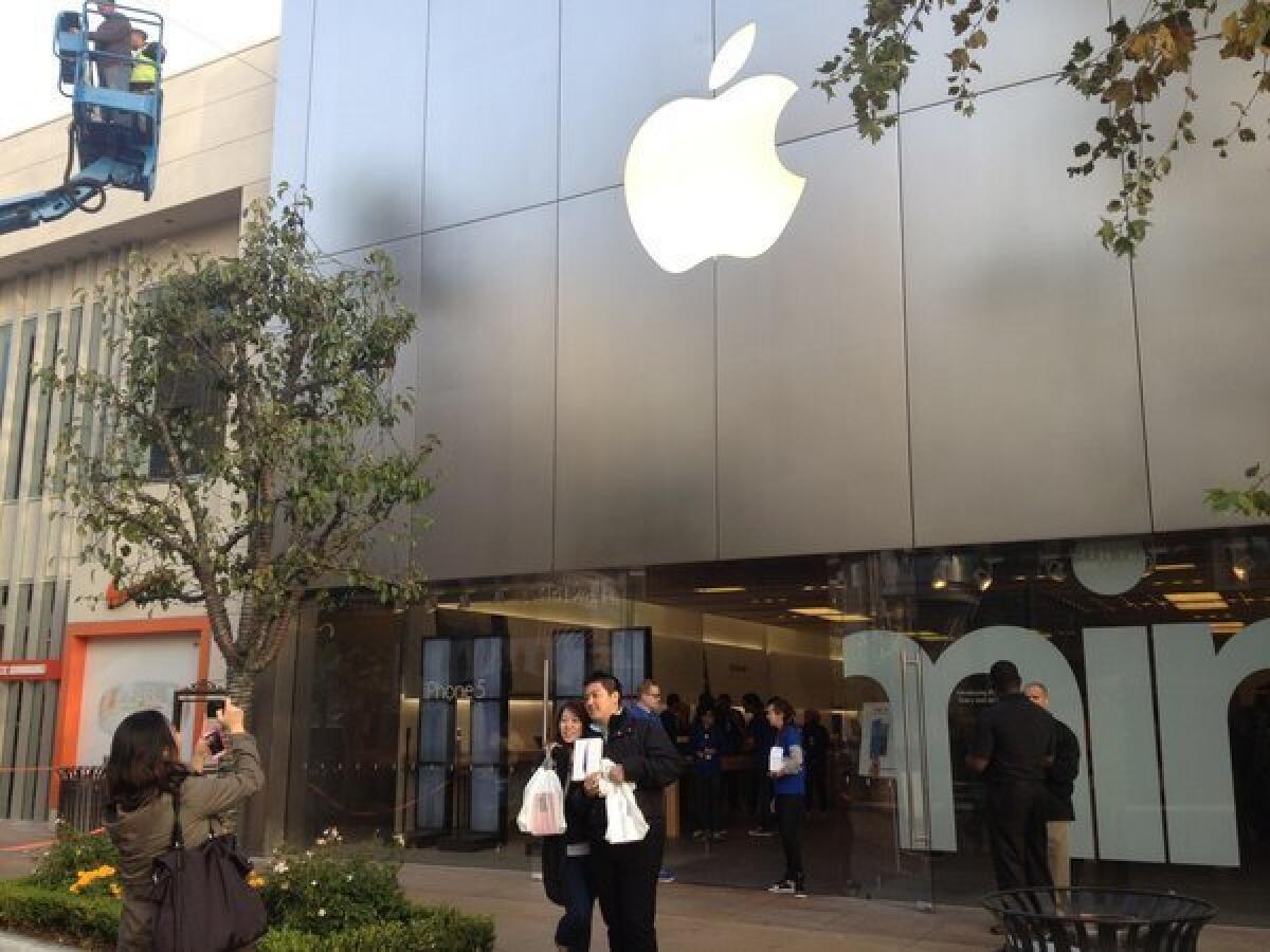 Taiwanese tourists with their new iPad minis pose for launch-day photos at the Apple store in L.A.'s Fairfax district.