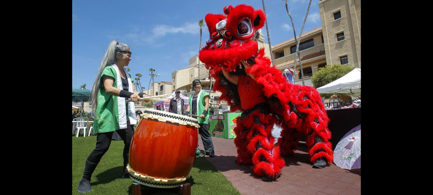 Kathy Tanaka of Japanese drumming group Naruwan Taiko drums as the Lucky Lion Dancers do a Chinese lion dance.