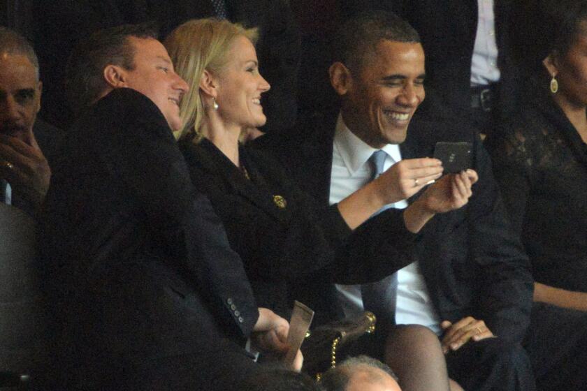 Danish Prime Minister Helle Thorning-Schmidt captures a moment with her cellphone camera during a memorial gathering Tuesday for South African freedom fighter Nelson Mandela, with British Prime Minister David Cameron, left, and President Obama. Their laughter and "selfie" snapping drew criticism from political opponents, while others saw it as in keeping with Mandela's own playful, upbeat spirit.