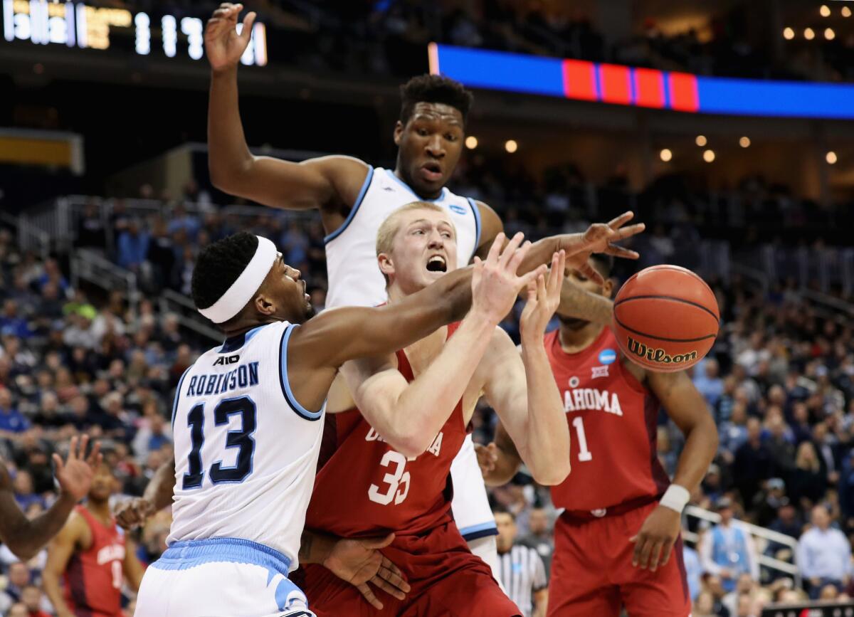 Oklahoma's Brady Manek (35) loses the ball on a block by Rhode Island's Stanford Robinson.