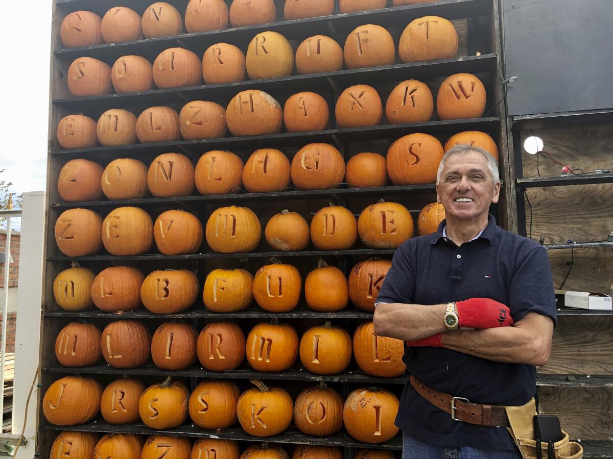 A smiling Ric Griffith stands next to jack-o'-lanterns carved for display at his Pumpkin House in Kenova, W.Va. 