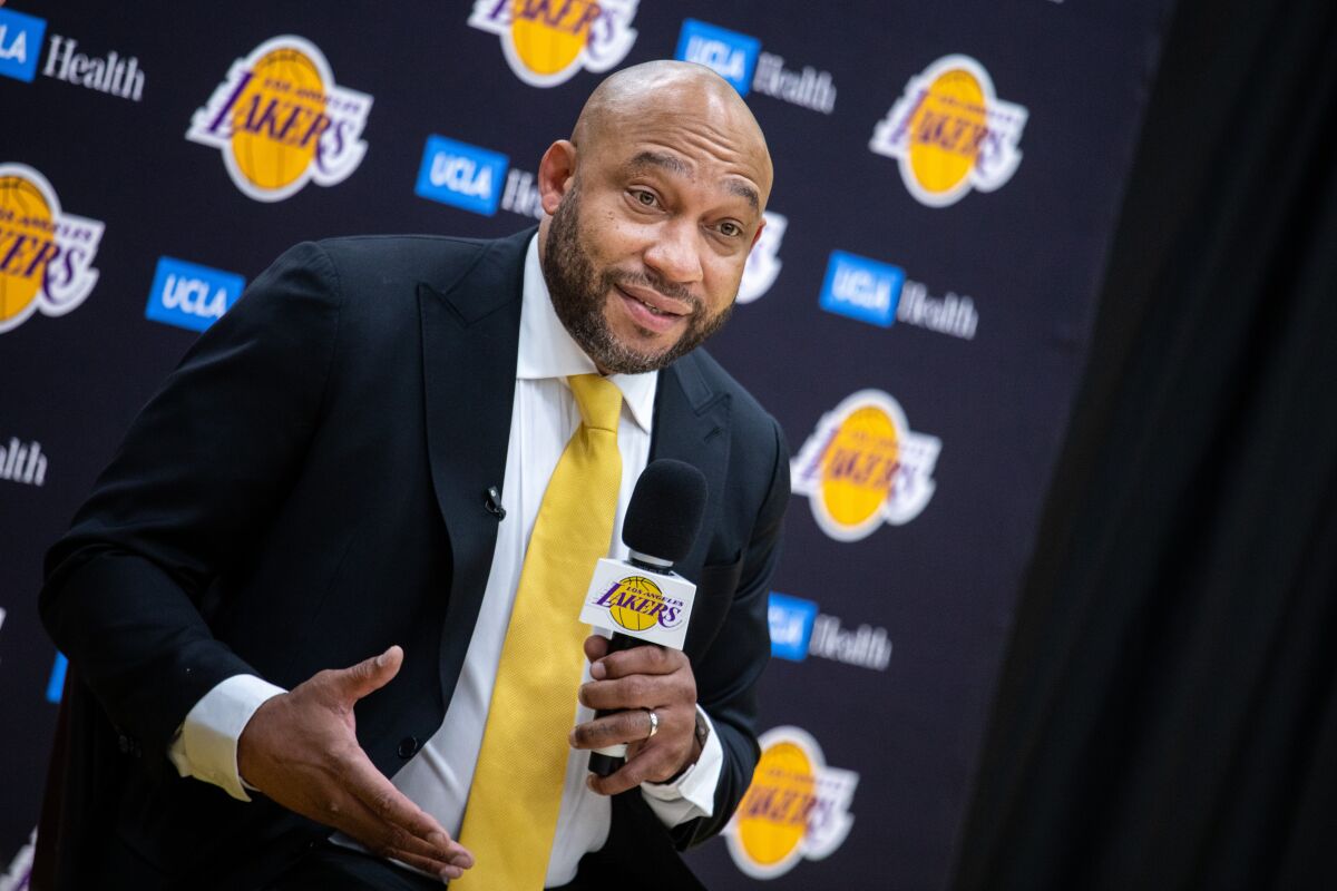 New Lakers coach Darvin Ham handles a microphone as he answers a question.