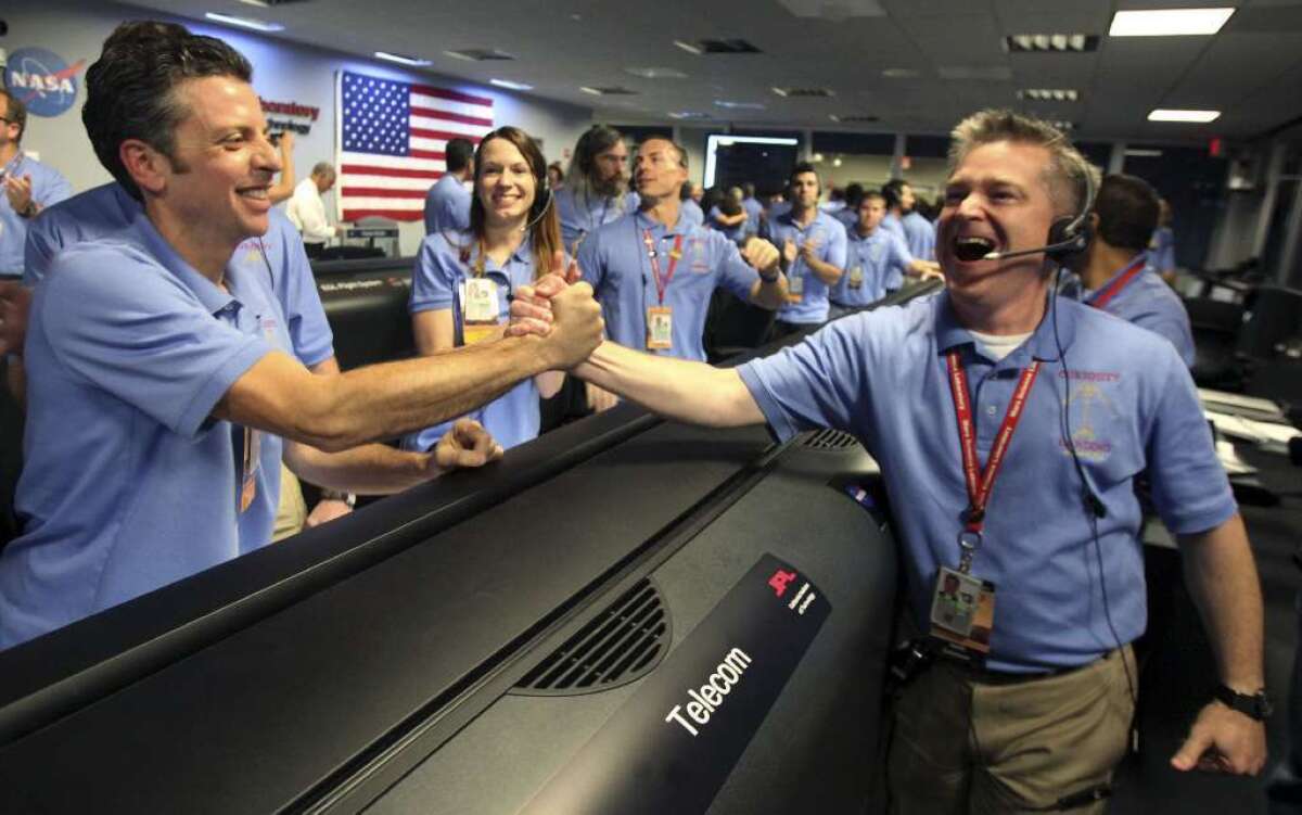 Flight director Keith Comeaux, right, and Martin Greco are jubilant in JPL's mission control room, which erupted in cheers after receiving word of Curiosity's successful landing on Mars.