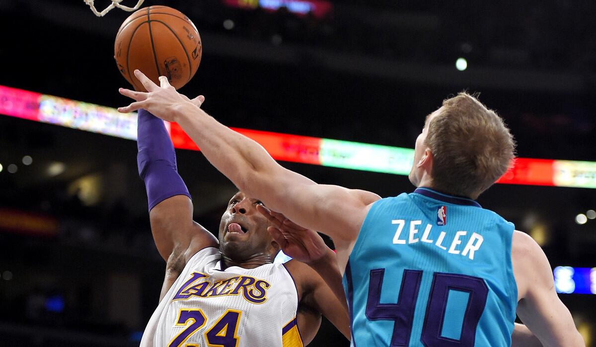 Lakers guard Kobe Bryant tries to score over the challenge of Hornets center Cody Zeller in the first half.