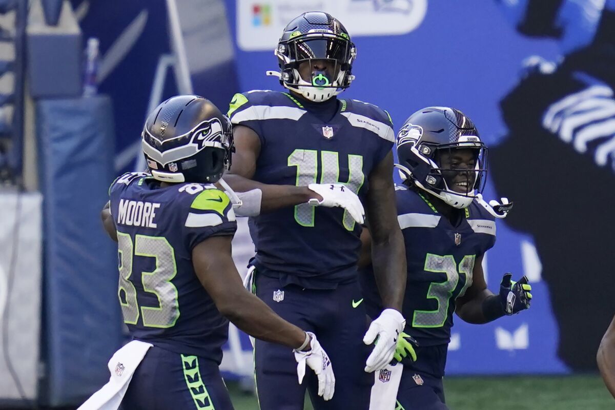 Seattle Seahawks wide receiver DK Metcalf (14) celebrates with teammates David Moore, left, and DeeJay Dallas, right, after Metcalf scored a touchdown against the San Francisco 49ers during the first half of an NFL football game, Sunday, Nov. 1, 2020, in Seattle. (AP Photo/Elaine Thompson)
