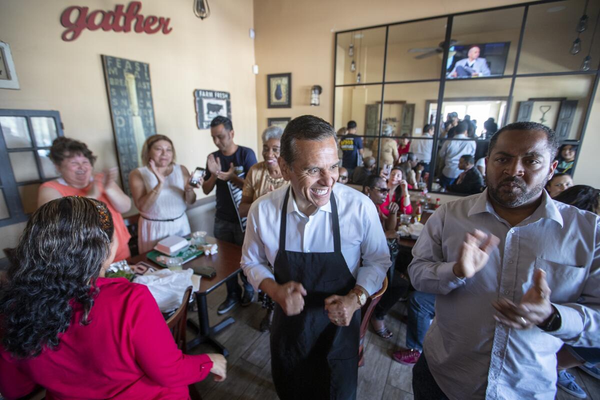 Gubernatorial candidate Antonio Villaraigosa put on an apron and served customers Monday while campaigning at Dulan's Soul Food on Crenshaw.