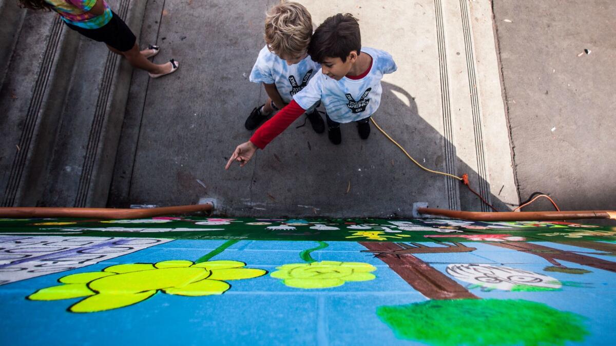 Third-graders Asher Levine, left, and Parsa Montazeri, both 9, examine new mural at West Hollywood Elementary School.